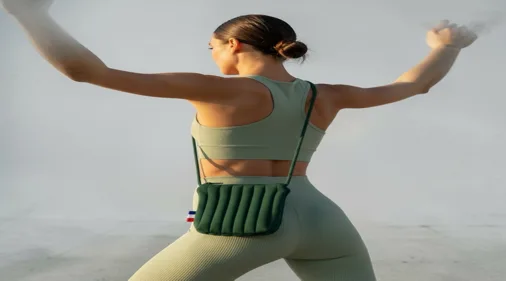 Femme en tenue de sport portant un sac banane vert ZeCabas